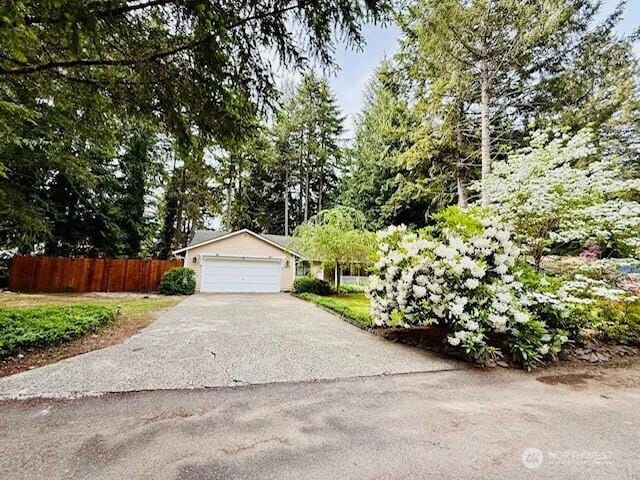 view of front of house with fence, a garage, and driveway