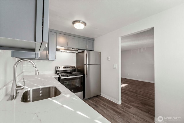 5211 E 96th St, Tacoma, WA 98446 - kitchen with appliances with stainless steel finishes, a sink, gray cabinets, under cabinet range hood, and light stone countertops