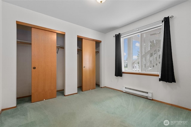 236 W Maberry Dr Unit 102, Lynden, WA 98264 - unfurnished bedroom with a baseboard heating unit, two closets, carpet floors, and baseboards