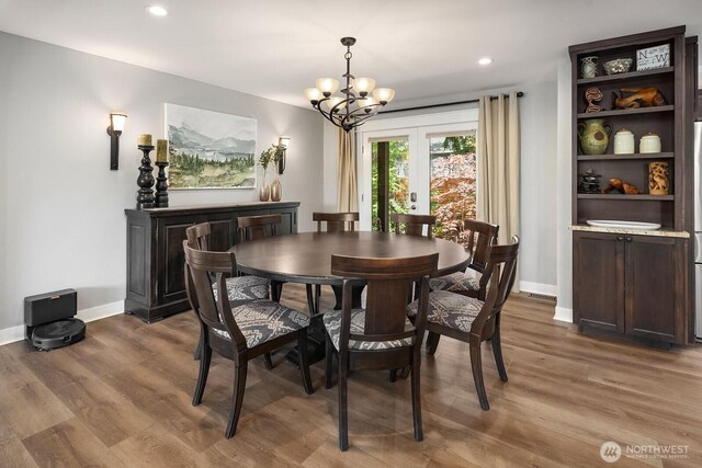 dining space featuring a chandelier, baseboards, wood finished floors, and recessed lighting