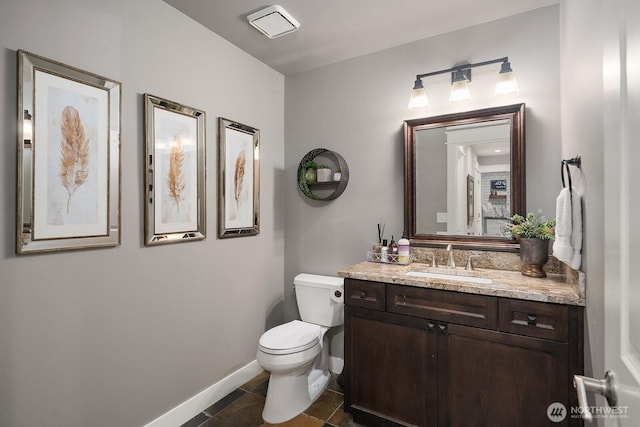 bathroom with toilet, baseboards, vanity, and tile patterned floors