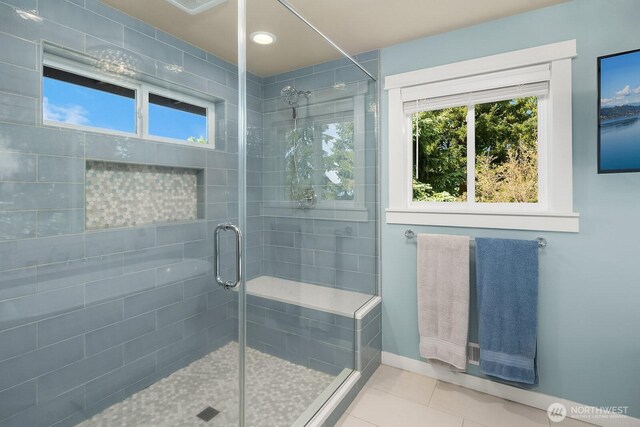full bathroom featuring a stall shower, tile patterned flooring, and baseboards