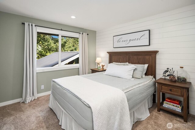 bedroom with light carpet, recessed lighting, wooden walls, and baseboards
