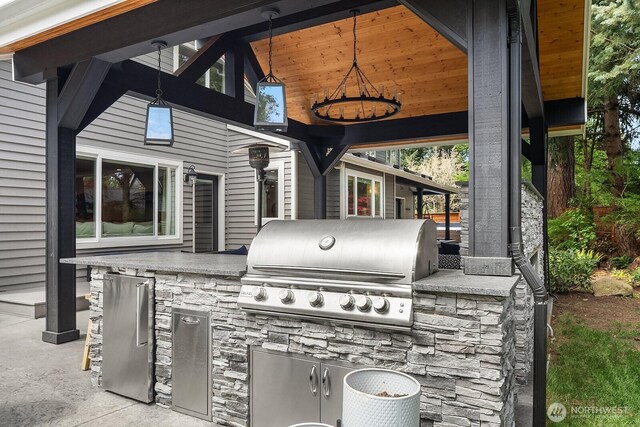 view of patio featuring exterior kitchen and a grill