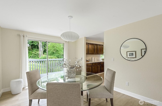 dining room featuring light wood-type flooring and baseboards