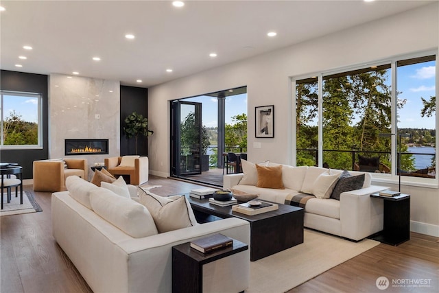 living room with recessed lighting, plenty of natural light, wood finished floors, and baseboards