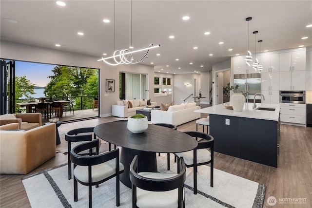 dining area with recessed lighting, plenty of natural light, wood finished floors, and a chandelier