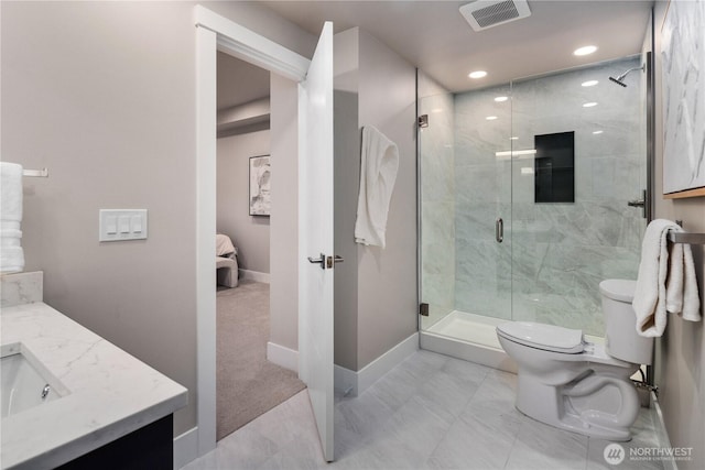 bathroom with baseboards, toilet, vanity, a stall shower, and recessed lighting