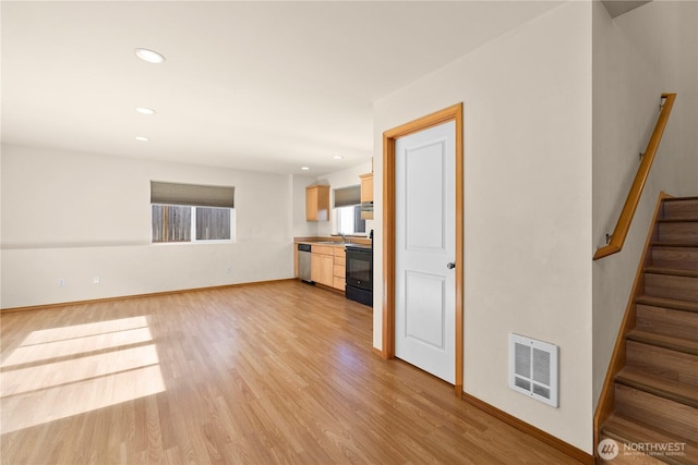 unfurnished living room featuring light wood finished floors, a sink, stairs, recessed lighting, and baseboards