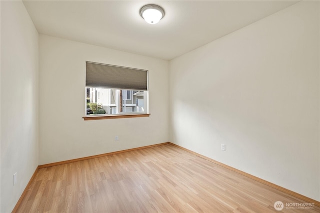spare room featuring wood finished floors and baseboards