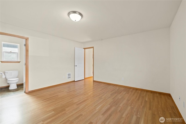 spare room with light wood finished floors and baseboards