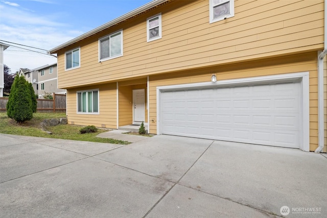 view of front of home featuring a garage, driveway, and fence