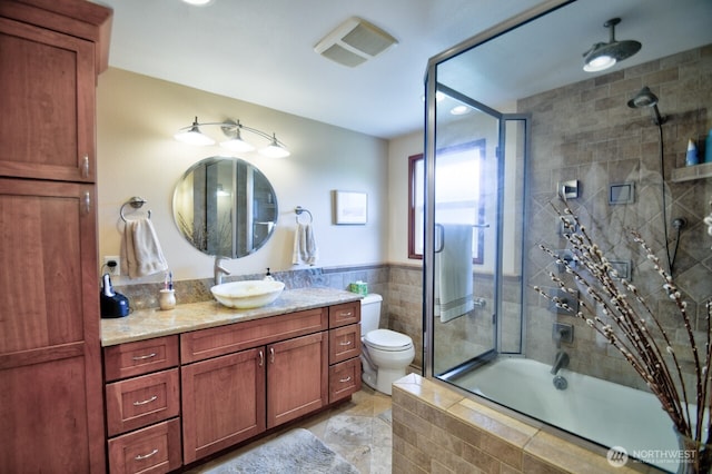 1260 S Karl Johan Ave, Tacoma, WA 98465 - bathroom featuring vanity, toilet, tile walls, and a combined bath / shower with rainfall shower