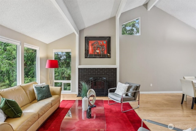 living room featuring wood finished floors, a fireplace, a textured ceiling, and baseboards