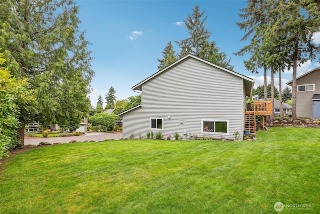 view of home's exterior featuring a lawn and a deck