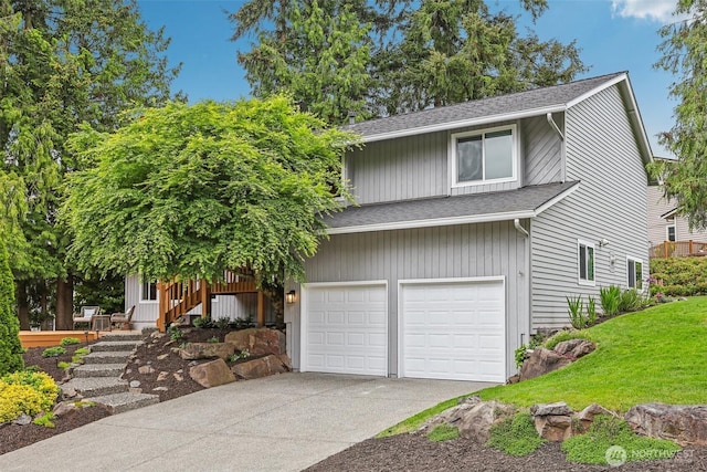 view of front of property featuring a shingled roof, a garage, driveway, and a front lawn