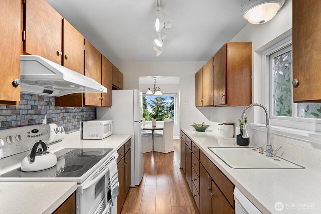 11515 Greenwood Ave N Unit B, Seattle, WA 98133 - kitchen with white appliances, under cabinet range hood, light countertops, and light wood-type flooring