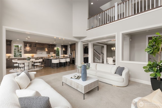 living room featuring a high ceiling, stairs, and recessed lighting