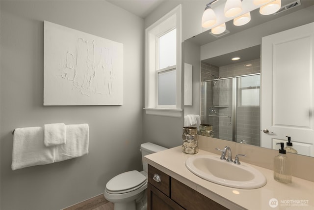 bathroom with toilet, a shower stall, vanity, and wood finished floors