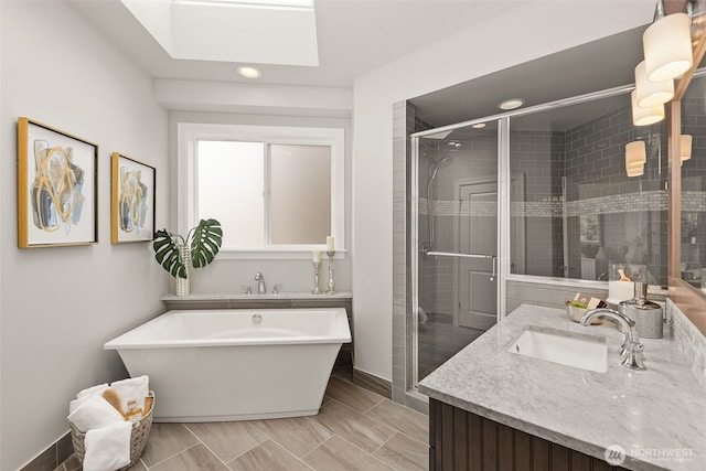 full bath with a skylight, a stall shower, vanity, baseboards, and recessed lighting