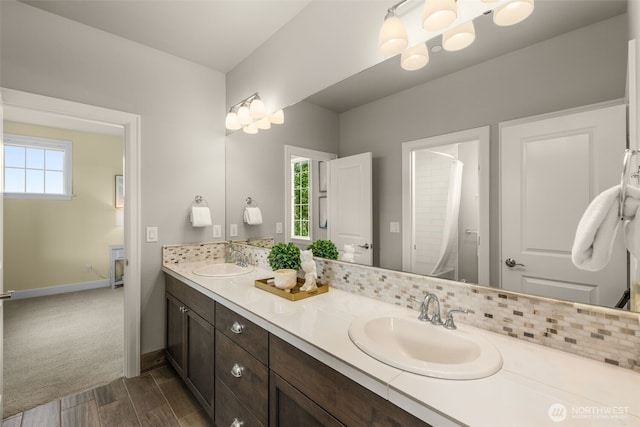 full bath featuring wood finished floors, double vanity, baseboards, and curtained shower