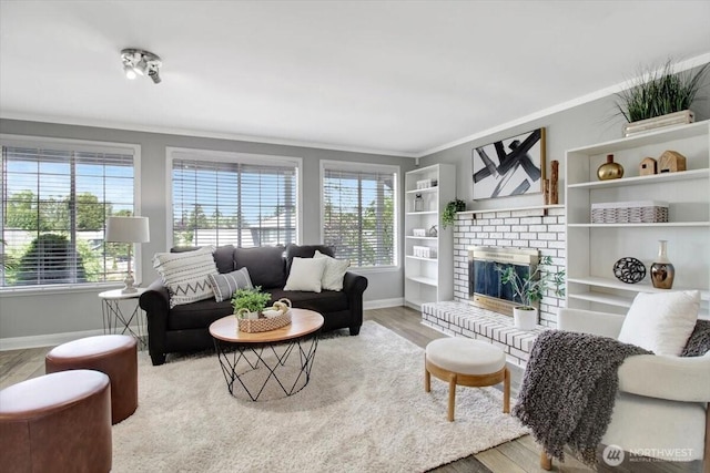 2711 NE 4th Ct, Renton, WA 98056 - living area featuring baseboards, wood finished floors, crown molding, and a brick fireplace