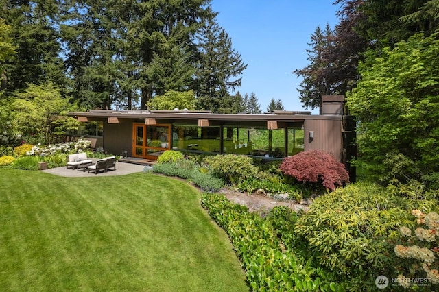 back of property with a yard, a patio, and an outdoor living space