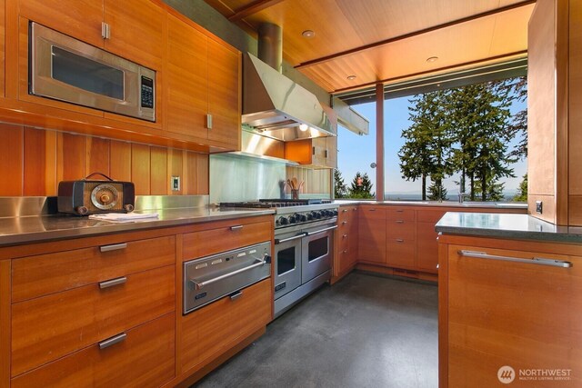 kitchen featuring stainless steel counters, appliances with stainless steel finishes, a warming drawer, and brown cabinets