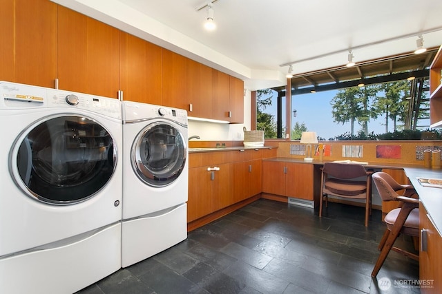 laundry room with rail lighting, separate washer and dryer, and cabinet space