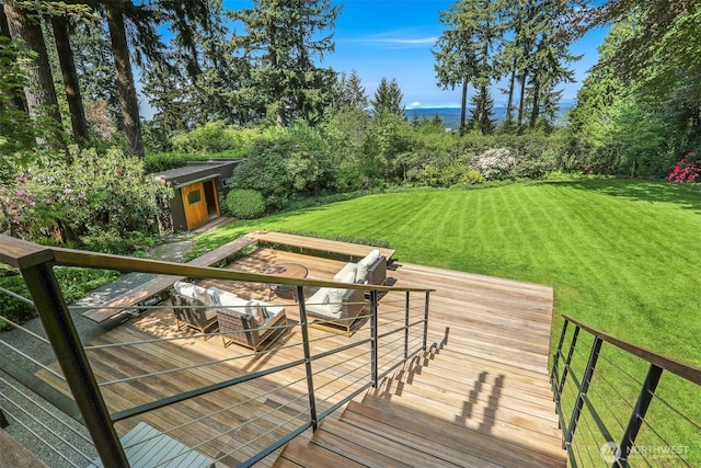 deck featuring a yard, an outdoor structure, and a storage shed