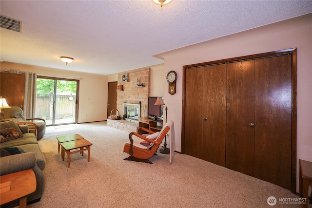 carpeted living room featuring a fireplace, a textured ceiling, and baseboards