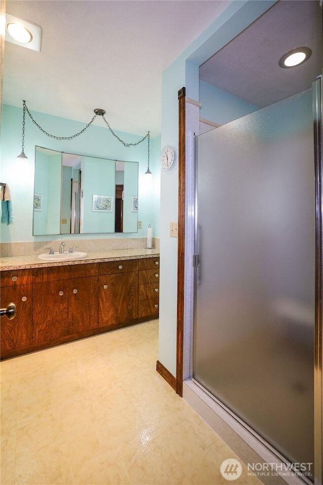 full bath with a shower stall, vanity, and tile patterned floors