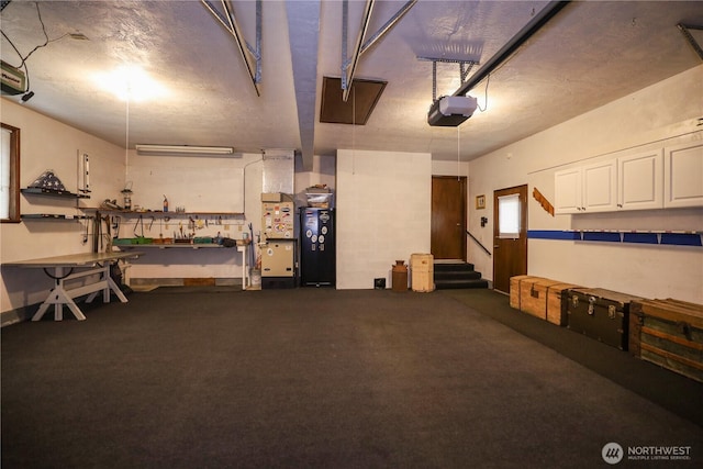 garage with a garage door opener and a workshop area