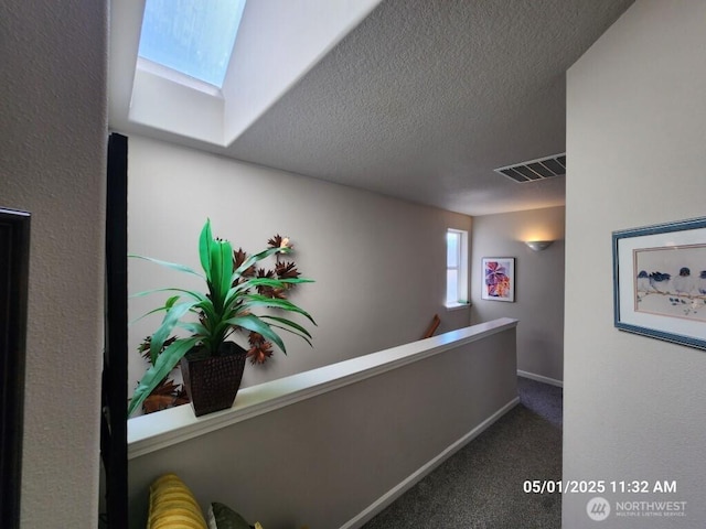 13816 NE 63rd St, Vancouver, WA 98682 - hallway with a skylight, carpet, an upstairs landing, a textured ceiling, and baseboards