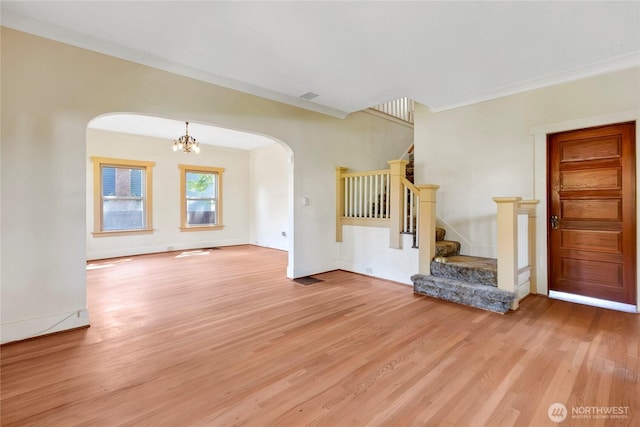 1420 S Verde St, Tacoma, WA 98405 - unfurnished living room with arched walkways, light wood-style floors, stairway, a chandelier, and baseboards