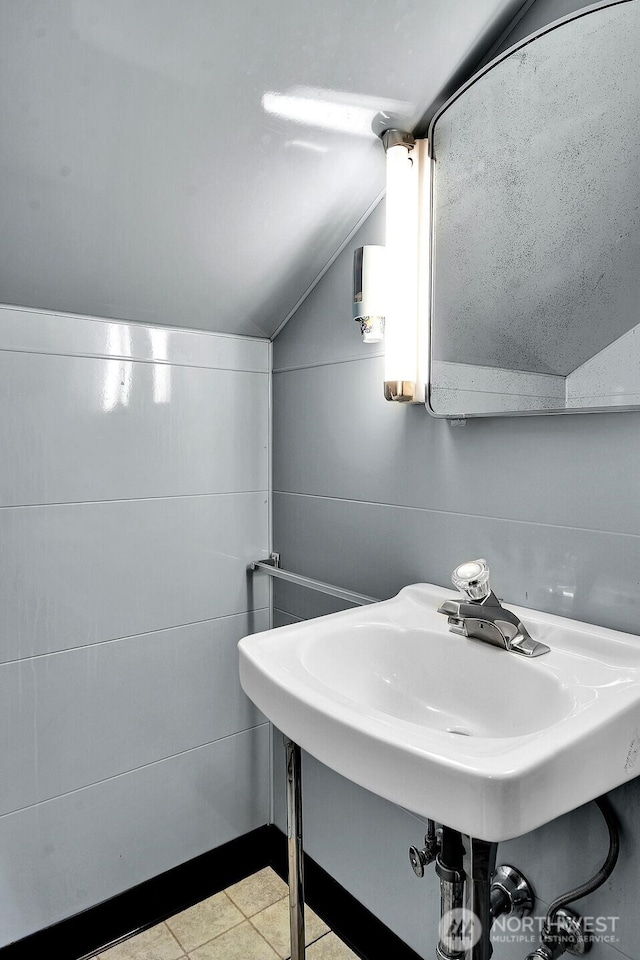 bathroom with vaulted ceiling and tile patterned flooring