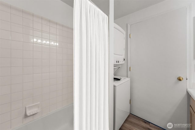 laundry room featuring stacked washing machine and dryer and dark wood-style flooring