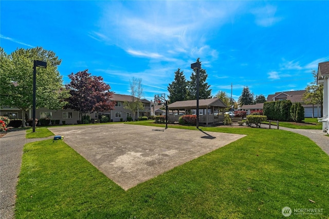 view of property's community with a lawn, a residential view, and uncovered parking