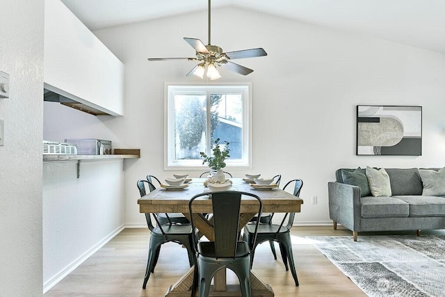 dining room with a ceiling fan, light wood-style flooring, baseboards, and lofted ceiling