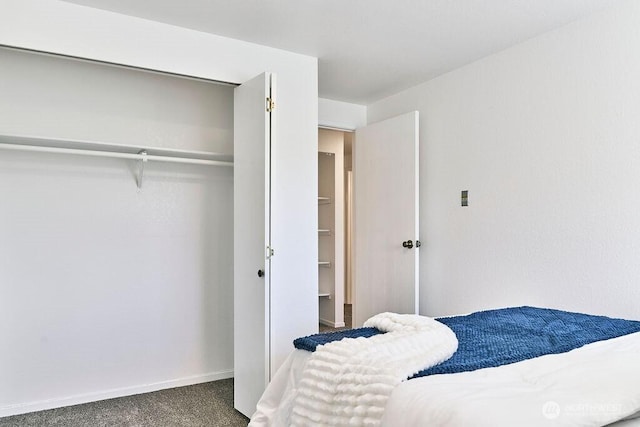 carpeted bedroom featuring a closet and baseboards