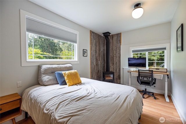 35717 321st St NE, Arlington, WA 98223 - bedroom with multiple windows, light wood-type flooring, and a wood stove