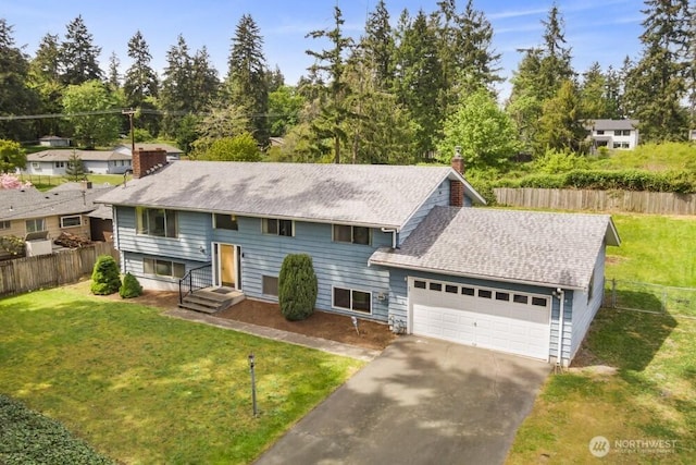 bi-level home with a chimney, an attached garage, driveway, and roof with shingles