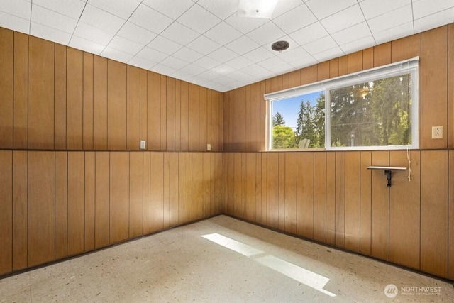 spare room with wood walls