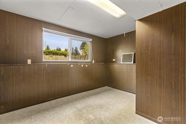 empty room with wood walls and light flooring