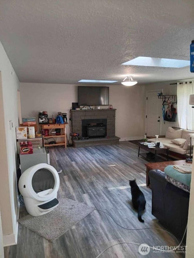11705 Silver Way, Everett, WA 98208 - living area with wood finished floors, a textured ceiling, a fireplace with raised hearth, and baseboards