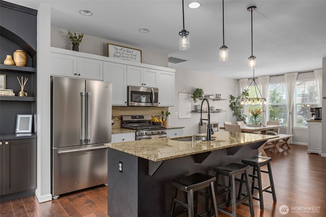 13708 Big Sky Dr E, Bonney Lake, WA 98391 - kitchen with appliances with stainless steel finishes, a sink, dark wood-type flooring, light stone countertops, and white cabinets