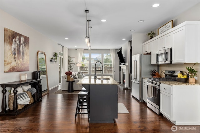 13708 Big Sky Dr E, Bonney Lake, WA 98391 - kitchen featuring stainless steel appliances, a sink, light stone counters, white cabinetry, and recessed lighting