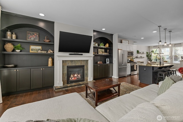 13708 Big Sky Dr E, Bonney Lake, WA 98391 - living area with dark wood-style floors, recessed lighting, a tiled fireplace, and built in features
