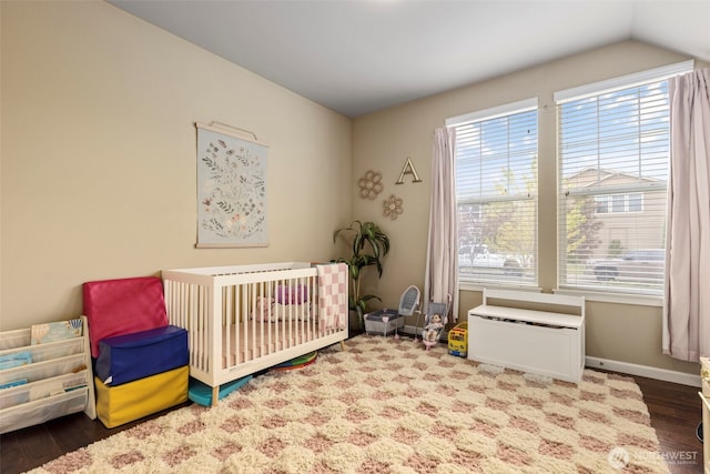 13708 Big Sky Dr E, Bonney Lake, WA 98391 - bedroom featuring a nursery area, wood finished floors, vaulted ceiling, and baseboards