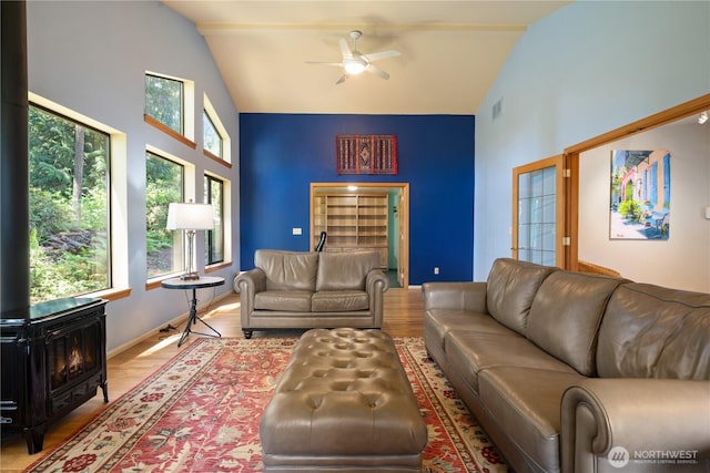 3912 Sutherland St, Gig Harbor, WA 98332 - living room with high vaulted ceiling, ceiling fan, a wood stove, wood finished floors, and baseboards